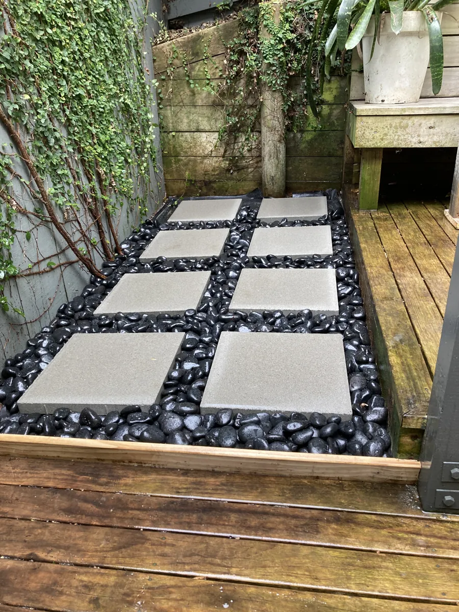 A stepping-stone and pebble path beside a timber deck, Auckland